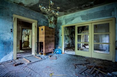 Ein Zimmer mit einem Kamin und einer kaputten Tür