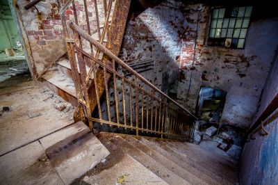 Eine Treppe in einem alten Gebäude mit einem kaputten Geländer