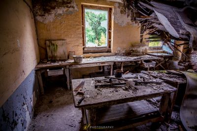 Ein Zimmer mit einem kaputten Fenster und einem kaputten Stuhl