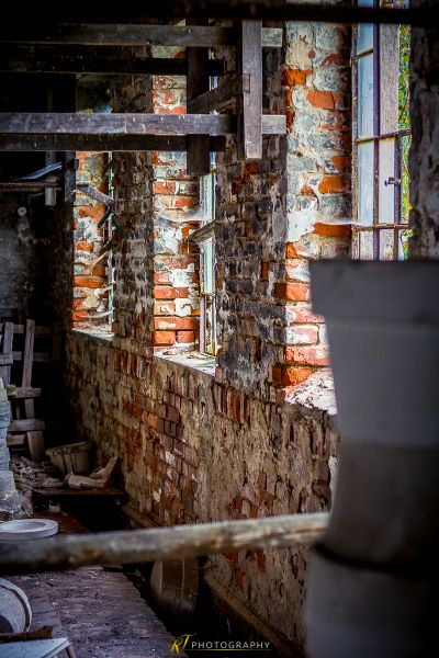 Eine Ziegelwand mit einem zerbrochenen Fenster in der Mitte