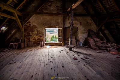 Ein Zimmer mit Stuhl und Fenster