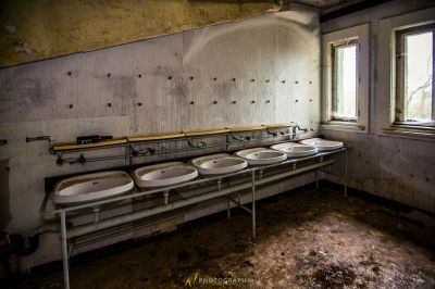 Ein Badezimmer mit drei Waschbecken und einem Fenster