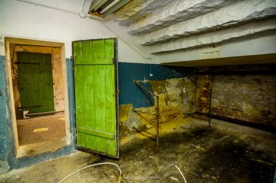 Ein Zimmer mit einer grünen Tür und einem Stuhl