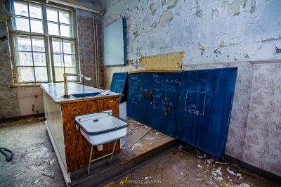 Ein schmutziges Badezimmer mit einer kaputten Toilette und einer blauen Wand