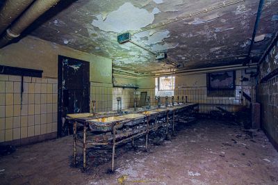 Ein schmutziges Zimmer mit einer zerbrochenen Decke und einem gebrochenen Waschbecken