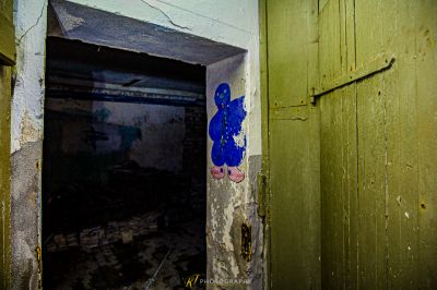 Eine Tür in einem Raum mit einem Graffiti an der Wand