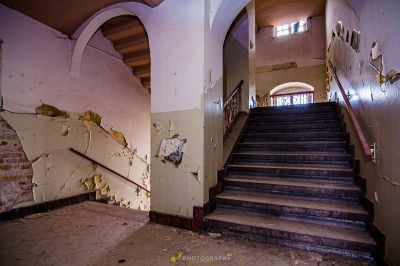 Eine Treppe in einem verlassenen Gebäude mit schälender Farbe