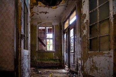 Ein Zimmer mit einer kaputten Tür und einem Fenster