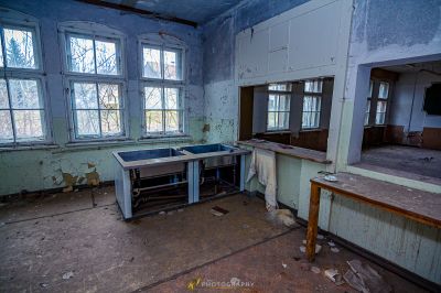 Ein Zimmer mit einem gebrochenen Waschbecken und einem Fenster