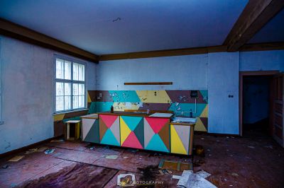 Ein Zimmer mit einem Schreibtisch und einem Fenster