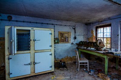 Ein Zimmer mit einem weißen Kühlschrank und einem Tisch