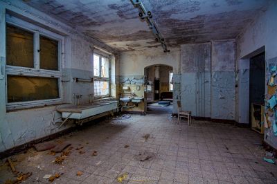 Ein Zimmer mit einem kaputten Kühlschrank und einem kaputten Fenster