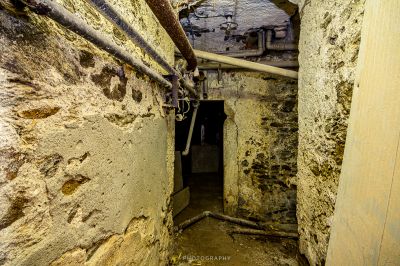 Ein schmaler Raum mit einem Rohr und einer Wand