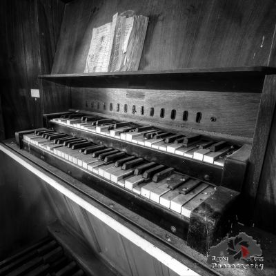 Ein altes Klavier in einem Raum mit Holzboden