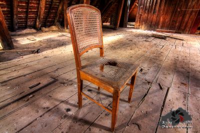 Ein Stuhl, der auf einem hölzernen Boden in einer Scheune sitzt