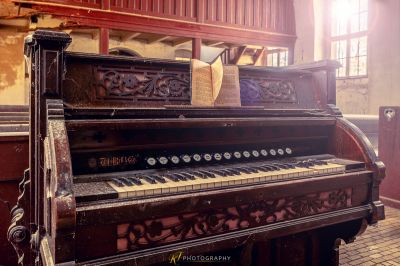 Ein Klavier, das auf einem Ziegelboden in einem Raum sitzt