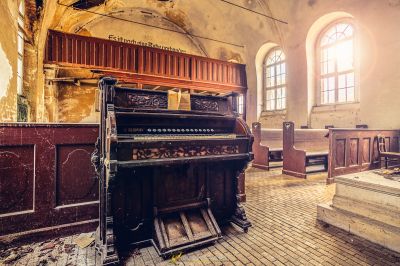 Ein Klavier in einer Kirche mit einem Fenster
