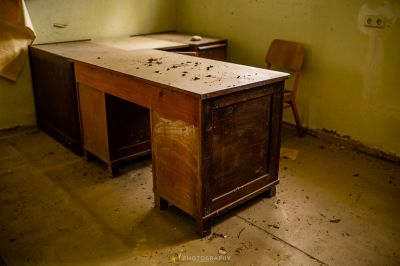 Ein Schreibtisch und Stuhl in einem Raum mit einer Wand