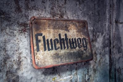 Ein verrostetes Schild an der Wand, die fukug sagt