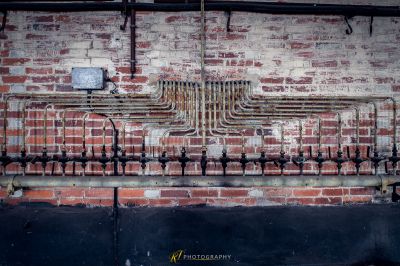 Eine Wand mit Rohren und einer Ziegelwand