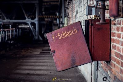 Ein rotes Buch, das an einer Ziegelwand hängt