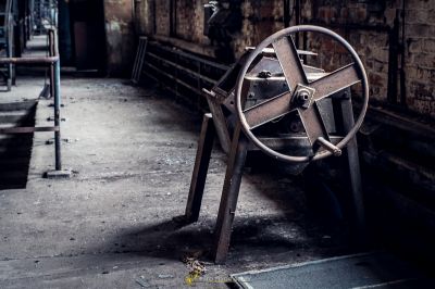 Ein großes Metallrad in einem schmutzigen Raum