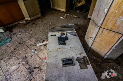 Eine schmutzige Küche mit einem kaputten Herd und einem kaputten Kühlschrank