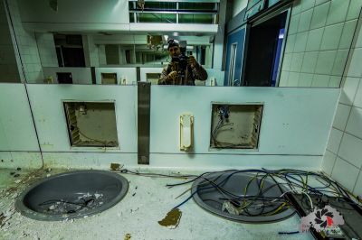 Ein Mann in einem Raum mit Waschbecken und Spiegel