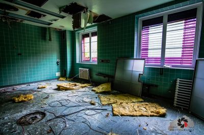 Ein Zimmer mit einem kaputten Fenster und einem Haufen Schutt