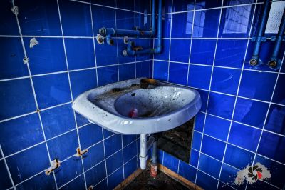 Ein schmutziges Badezimmer mit Waschbecken und Toilette