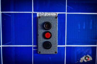 Ein rotes Licht auf einer blau gefliesten Wand