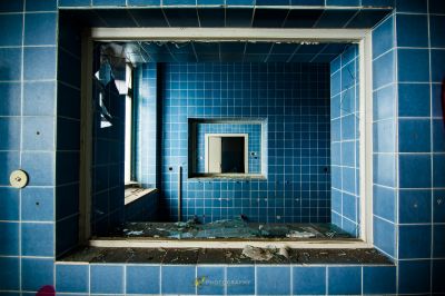 Ein Badezimmer mit einem gebrochenen Spiegel und einem gebrochenen Waschbecken