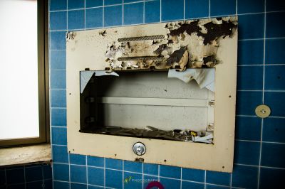 Ein schmutziges Badezimmer mit einem kaputten Fenster und einer kaputten Toilette