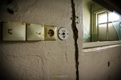 Eine Wand mit einem kaputten Lichtschalter