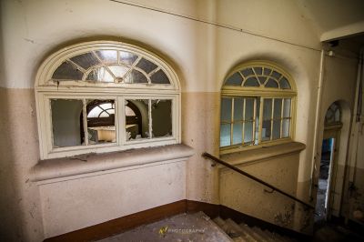 Ein Zimmer mit Fenster und Stuhl