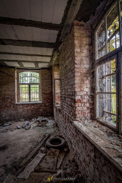 Ein Zimmer mit einem kaputten Fenster und einer kaputten Toilette