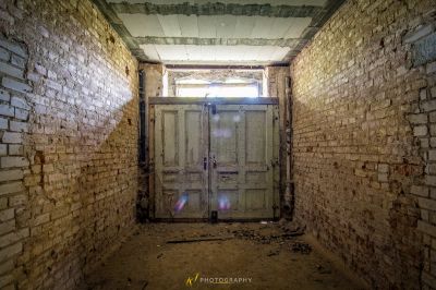 Eine Tür in der Ziegelmauer mit einem Licht, das durch sie leuchtet