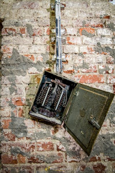 Eine zerbrochene elektrische Box auf einer Ziegelwand