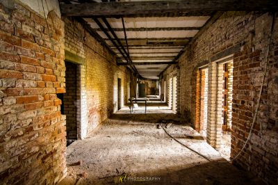 Einen langen Flur mit einer Ziegelwand und einem zerbrochenen Fenster