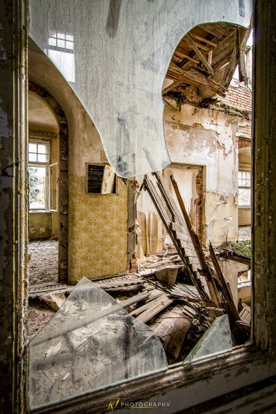 Ein Zimmer mit einem kaputten Fenster und einer kaputten Wand