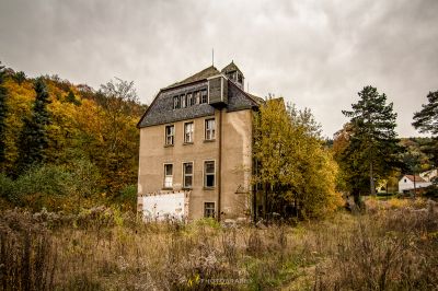 Ein sehr altes Haus auf einem Feld aus hohem Gras