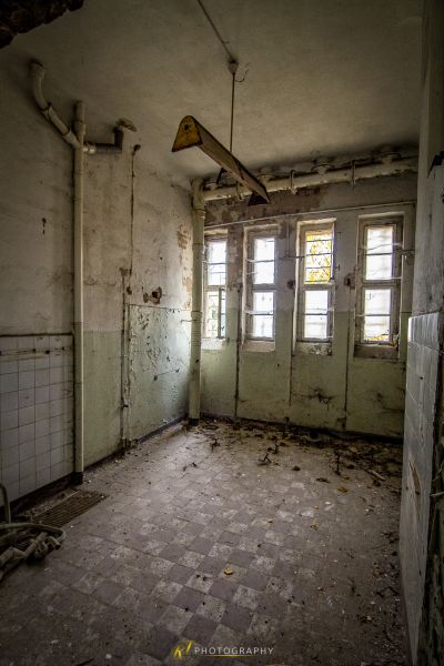 Ein Zimmer mit Fenster und Fliesenboden