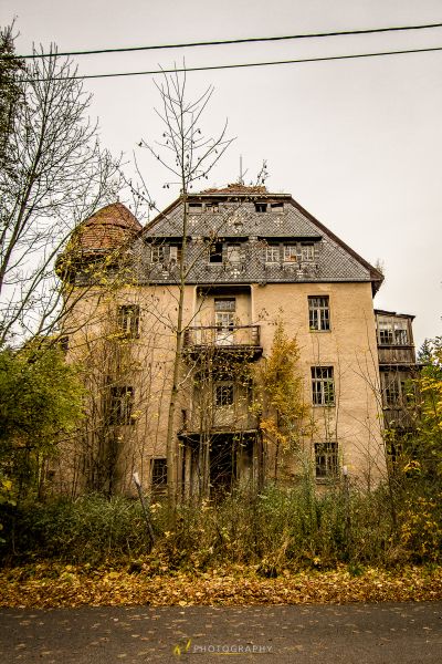 Ein sehr altes Haus mit vielen Blättern auf dem Boden