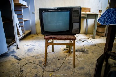 Ein Fernseher, der auf einem Stuhl in einem Zimmer sitzt