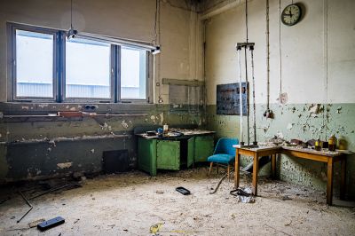 Ein Zimmer mit einem Schreibtisch und einem Fenster