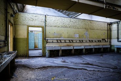 Ein schmutziges Zimmer mit einer Bank und einer Wand