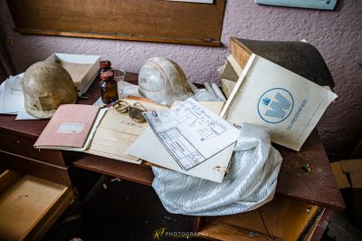 Ein Tisch mit einem Haufen Papieren und einer Flasche Wein
