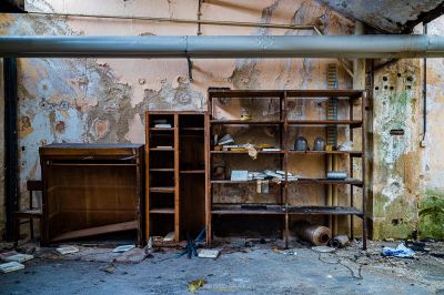 Ein Zimmer mit einem Schreibtisch und Regalen in ihm