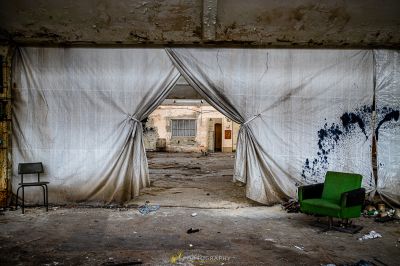 Ein Stuhl in einem Raum mit einem Vorhang darüber