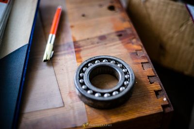 Ein Bleistift und ein Kugellager auf einem Holztisch